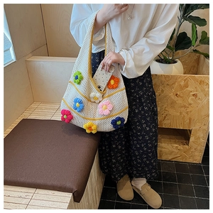 Détail du sac à bandoulière en tricot ajouré avec motifs de fleurs 3D colorées au crochet