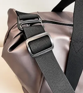 Detail der verstellbaren Nylonschlaufe und matten Schnalle einer Metallic-Tragetasche