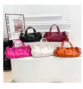 Close-up of pleated baguette bags in five colors with drawstring details and dual handles