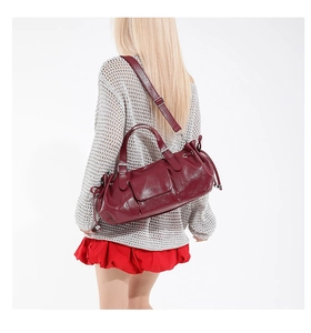 Rear view of model wearing a burgundy leather shoulder bag with chic ruched details