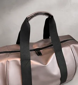 Detail der wasserfesten Reisetasche mit metallic Champagner Stoff und schwarzen Henkeln