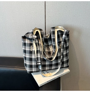 Detail of checkered canvas tote bag with adjustable shoulder strap and sturdy texture