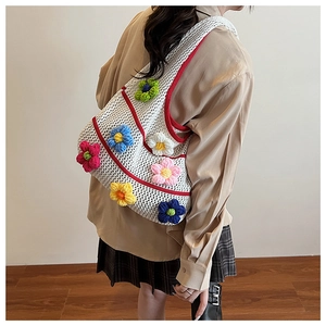 Détail du sac cabas blanc crocheté à la main avec fleurs tricotées et motif ajouré chic