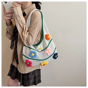 Détail du sac cabas en tricot blanc avec fleurs au crochet 3D et bordure verte tendance