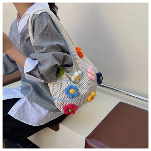 Gros plan d'un sac bandoulière au crochet blanc avec décorations de fleurs tricotées en 3D
