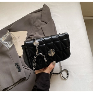 Detail of black quilted PU leather shoulder bag with silver metal ball and chain strap