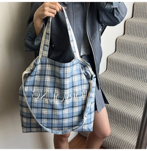 Detail of a large blue and white checkered canvas tote bag with FORYOUNG text logo