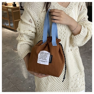 Detail of caramel canvas lunch bag with blue handles and drawstrings for daily commute