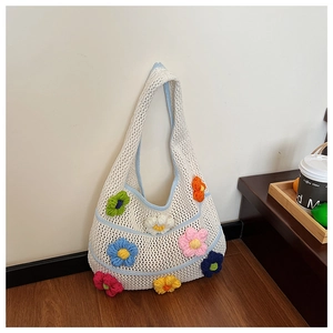 Détail du sac hobo en tricot évidé orné de fleurs colorées en crochet 3D