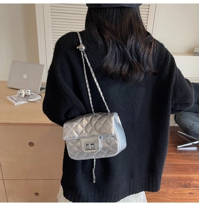 Détail du sac à chaîne argenté matelassé avec finition métallisée et fermoir carré