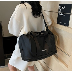 Close-up of black multifunctional travel bag with shoulder strap and durable material