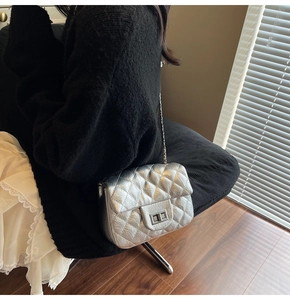 Gros plan du sac matelassé argenté avec chaîne, fini métallisé et fermoir sur le mannequin