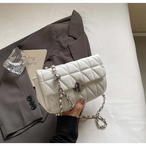 Detail of white quilted handbag with silver sphere ornament and elegant leather-chain strap