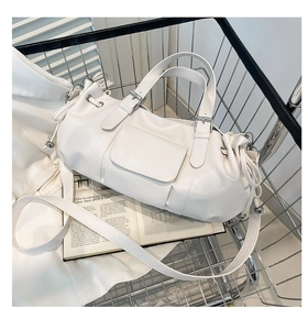 Detail of white pleated handbag in a shopping basket featuring silver buckle and strap