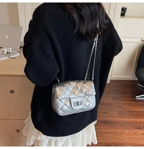 Détail du sac à bandoulière argenté à matelassage en losange porté par le modèle