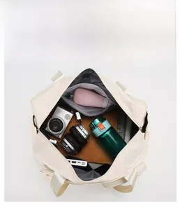 Top view of spacious beige travel bag with compartments for camera and accessories