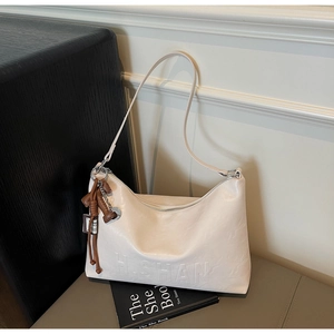 Detail of off-white leather shoulder bag with zipper closure and H.SHAN logo engraving