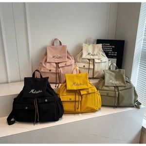 Group shot of colorful canvas backpacks showing variety of shades and embroidery details