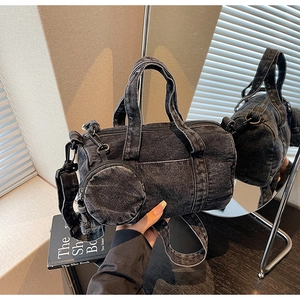 Detail of black denim cylinder bag with matching round coin purse and wide strap