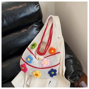 Détail d'un sac cabas en crochet blanc avec fleurs 3D colorées et bordures contrastées