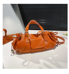 Detailed macro view of orange textured leather bag featuring front pocket and drawstrings