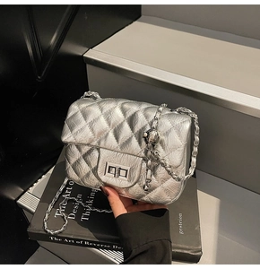 Détail du sac matelassé argenté avec cuir métallisé, chaîne et fermoir pivotant