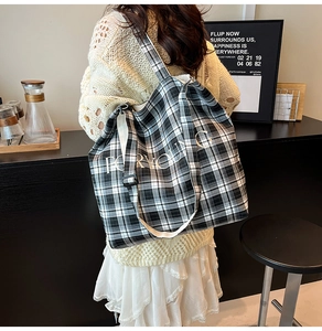 Detail of checkered tote bag with FOR YOUNG slogan and wide shoulder strap