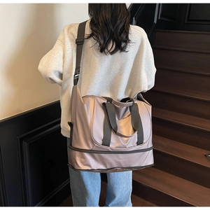 Detail of expandable duffel bag showing the bottom shoe compartment and side strap