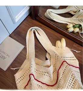 Detail of beige knit tote bag showing hollow weave patterns and red wavy edge accents