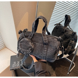Detail of black washed denim Boston bag with detachable round coin purse and shoulder strap