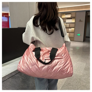 Close-up of metallic pink large capacity travel tote bag with quilted texture and straps
