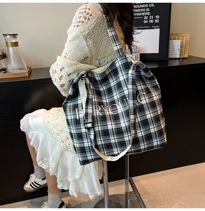 Close-up of black and white plaid tote bag with adjustable strap and FORYOUNG text