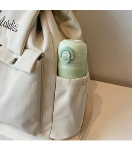 Detail view of durable canvas side pocket on a cream backpack with a green thermos cup
