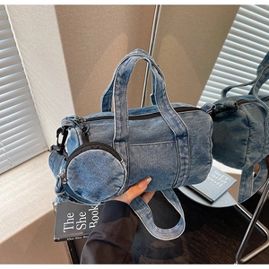 Detail of blue denim Boston bag with matching round coin purse and wide shoulder strap
