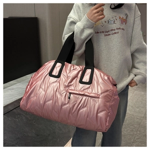 Quilted pink travel tote featuring a shimmering metallic finish and black woven straps