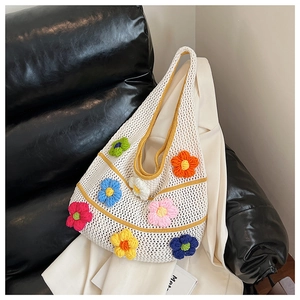 Gros plan sur un sac cabas en maille blanche avec broderies florales 3D colorées