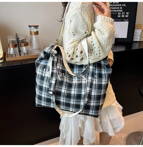 Detail of black and white checkered tote bag featuring large FOR YOUNG lettering print
