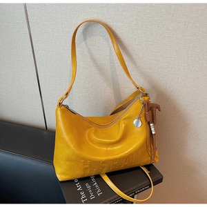 Detail of ginger yellow leather shoulder bag with H.SHAN relief and horse charm