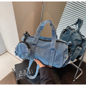 Detailed shot of a blue denim barrel bag with a mini pouch reflected in a mirror