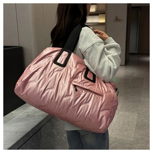 Close-up of pink quilted travel tote bag featuring waterproof nylon and black straps