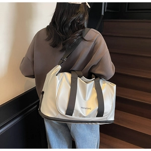 Detail view of silver travel bag with bottom compartment and adjustable shoulder strap