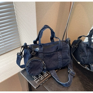 Detail of vintage navy denim cylinder bag with matching coin purse and woven strap