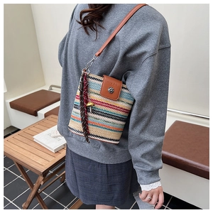 Détail du sac seau tissé arc-en-ciel bohème avec rabat en cuir et boucle vintage