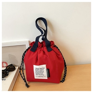 Red canvas lunch bag featuring drawstring closure and contrast blue handles