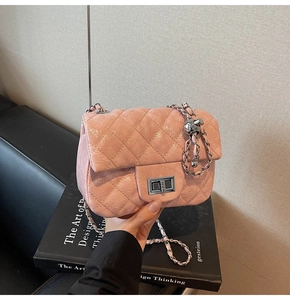 Détail du sac en cuir matelassé rose avec chaîne argentée et boule en métal
