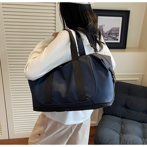 Detailed shot of dark blue waterproof travel bag with bottom shoe compartment and handles