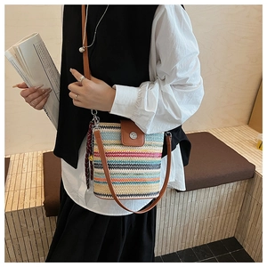 Détail du sac seau tissé arc-en-ciel avec rabat en cuir marron et foulard en soie