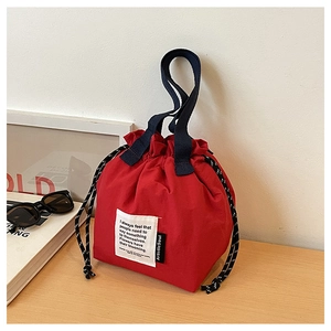 Detail of red drawstring lunch bag with thick canvas fabric and stylish quote patch