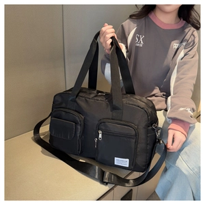Detail of black nylon fitness bag with two front zipper pockets and adjustable strap