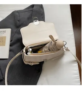 Dettaglio dell'interno della borsa beige a quadretti che mostra la capienza per l'uso diario